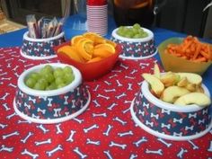 there are many different bowls of food on the table with red and blue cloths