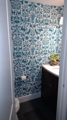 a bathroom with blue and white wallpaper in it