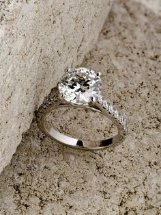 a diamond ring sitting on top of a stone wall