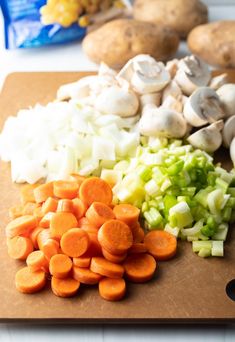 chopped carrots, celery, onions and mushrooms on a cutting board