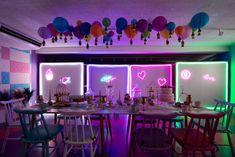 a dining room with colorful lights and balloons hanging from the ceiling