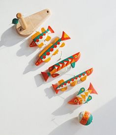 an assortment of colorful wooden ornaments on a white surface