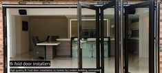 an open glass door leading to a kitchen and dining area with brick wall behind it