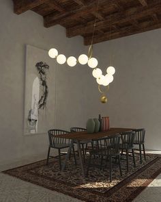 a dining room table and chairs with lights hanging from the ceiling over it's head