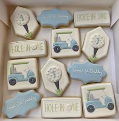 decorated cookies in the shape of tractors and golf related items are arranged in a box