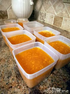 six plastic containers filled with soup sitting on top of a counter