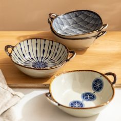 three bowls sitting on top of a wooden table