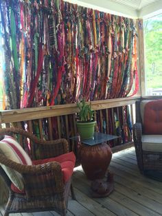 an outdoor area with wicker furniture and colorful ribbons on the wall