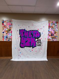 a large white banner with purple and blue spray paint on it in an empty room