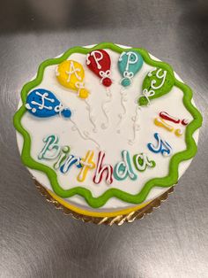 a birthday cupcake sitting on top of a metal surface with the words happy birthday written on it