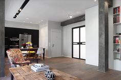 a living room filled with furniture and bookshelves next to a dining room table