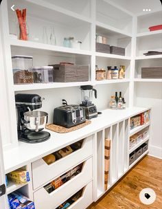 an organized pantry with white shelves and drawers