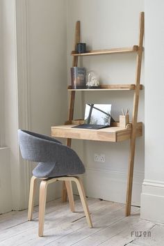 a wooden desk with a chair next to it and bookshelf in the corner