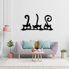 a living room with a couch, table and two cats silhouettes on the wall