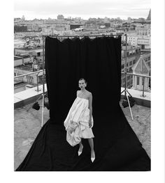 a black and white photo of a woman in a towel on top of a building