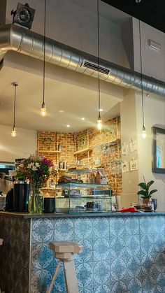 the interior of a restaurant with blue tiles and lights hanging from it's ceiling