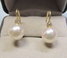 A classic pair of diamond and pearl earrings from the 1960's is set in 14Kt yellow gold with a European lever backs. These earrings can be worn dressy for occasions or sporty with jeans or basically all the time. The well matched high luster cultured pearls measure 7 millimeters and the approximate total weight of the two full cut diamonds is 0.08Ct. Classic Yellow Gold Diamond Earrings For Evening, Classic Hallmarked Diamond Earrings For Formal Occasions, Classic Hallmarked Diamond Earrings For Formal Events, Classic Round Diamond Earrings For Evening, Yellow Gold Round Diamond Earrings With Pearl Drop, Formal Yellow Gold Diamond Earrings With Pearl Drop, Anniversary Brilliant Cut Yellow Gold Pearl Earrings, Classic Pearl Earrings With Diamond Accents In Yellow Gold, Classic Yellow Gold Pearl Earrings With Diamond Accents