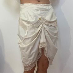 S Faux garter skirt in a lemony cream ! 🎀Best fits 27" -29" waist and hips under 35" 🎀Not sure? Reach out with your measurements so that I can adjust a mannequin to your size for a fitting. 🎀Hand or machine wash on delicates in cold water. Best to use a laundry bag to avoid the ribbons from getting caught. Hang dry. High Waist Gathered Skirt For Daywear, Vintage Fitted Mini Skirt With Tiered Design, Daywear Mini Skirt With Lace Trim, Vintage Fitted Tiered Mini Skirt, Stretch Mini Skirt For Daywear, Fitted Tiered Mini Skirt With Lace Trim, Fitted Hip-length Mini Skirt For Spring, Asymmetrical Skirt With Lace Trim For Summer, White Fitted Asymmetrical Skirt