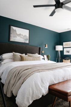 a large bed sitting under a ceiling fan in a bedroom