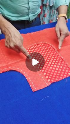 a person cutting out a piece of red paper