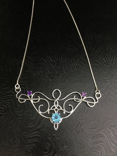 I love Victorian and Renaissance style statement necklaces with a magical and timeless flair, and I hope I've captured it within this piece! I shall fabricate for you this gorgeous Elvish/Renaissance style necklace, in sterling silver, with a center 8mm Blue Topaz and two side 4mm Amethyst gemstones. The center gemstone is 8mm round and the two sides are 4mm round. The chain will be soldered to each side and I will use a 1.2mm thick sterling box chain with a lobster claw clasp for added straight Blue Medieval Necklace, Victorian Blue Pendant Necklace, Victorian Hallmarked Purple Necklace, Blue Victorian Pendant Necklace, Silver Necklace With Intricate Art Nouveau Design, Victorian Boho, Sapphire Necklace, Moon Pendant, Box Chain