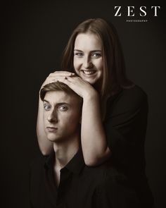 a young man and woman are posing for a photo in front of a black background