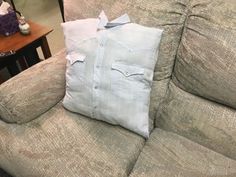 a couch with a pillow on it and some other items sitting on the couch in front of it