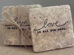 two square coasters with words on them