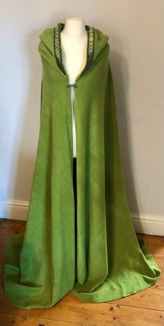 a green cape is shown on a mannequin