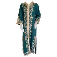 Elegant vintage Moroccan green caftan, poly jersey embroidered with black and gold threads design all-over. You could wear this maxi dress kaftan closed or open. The kaftan features a traditional neckline, with side slits and gently fluted embellished sleeves. It closes at the front with woven gold buttons and loops, could be open all the way down. Marrakech Bohemian, Yves Saint Laurent style. This Bohemian vintage 1970s style caftan is in perfect condition, dry cleaned and ready to wear. Size medium: Measurements: Bust: 41". Waist: 42". Hips: 42". Across shoulders: 18"5. Sleeve length: 19". Center back length: 56". Velvet Caftan, Emerald Green Maxi Dress, Moroccan Green, Dress Kaftan, 1970s Style, Designer Maxi Dress, Emo Dresses, Moroccan Caftan, African Traditional Dresses