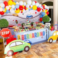 a birthday party with cars and balloons on the wall, including a sign that says benardino