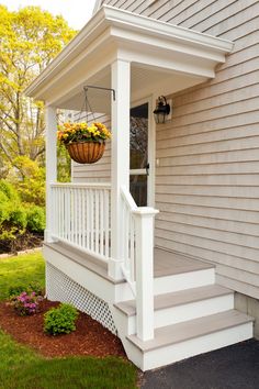 a white porch with flowers hanging from it