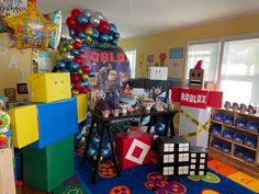 a room filled with lots of colorful balloons and decorations on the walls, including cubes