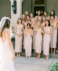 a group of women standing next to each other in front of a building with their mouths open