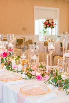 the table is set with candles, plates and flowers on it for a formal function