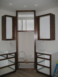 an empty bathroom with two sinks and cabinets