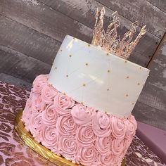 a pink and gold cake with a crown on top