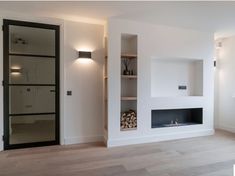 an empty living room with a fireplace and shelves on either side of the fire place