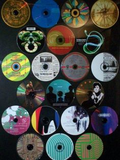 many different cd's are on display in a black case with white trimming