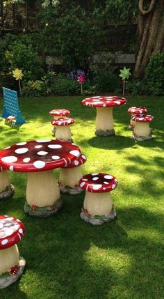 a group of red and white mushrooms sitting on top of lush green grass covered ground