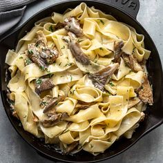 a skillet filled with pasta and mushrooms