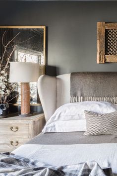 an image of a bed with white sheets and pillows on it, in front of a mirror