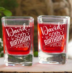 two shot glasses sitting on top of a wooden table