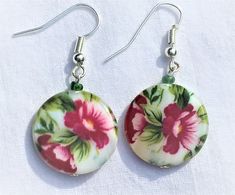 Red flower green leaves on white background beautiful gentle flower earrings. The color pattern is painted on mother pf pearl coin shaped shell beads. Available with lever back or fish hook (shown) closure - please choose.  Drop length 1.5 inches, bead size 19 mm.  These earrings make a perfect gift for a gardener who likes to plant flowers, or to a florist, or to any woman who likes flowers!  TO VIEW MY ENTIRE SHOP GO TO: https://www.etsy.com/shop/Voleena Fish Hooks Show, Background Beautiful, Flower Green, Red Flower, Shell Beads, Fish Hook, Flower Earrings, Red Flowers, Green Leaves