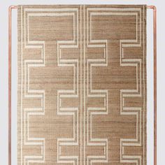 a brown and white area rug with squares on the bottom, in front of a metal frame