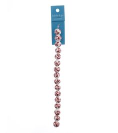 the beaded bracelet is pink and white with silver beads on each end, along with a blue tag