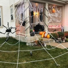 a house decorated for halloween with spider webs and pumpkins