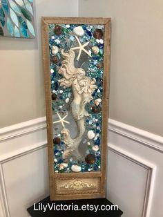 a mirror with seahorses and seashells on it in the corner of a room