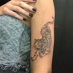 a woman's arm with a tiger tattoo on the left side of her body