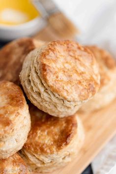 three biscuits stacked on top of each other on a cutting board next to a glass of orange juice